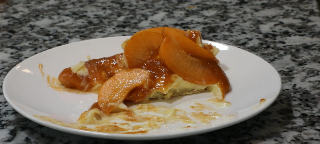 Apricot pie on plate being eaten.