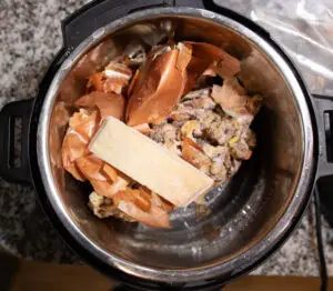 chicken carcass in pressure cooker with vegetables and parmesan rind