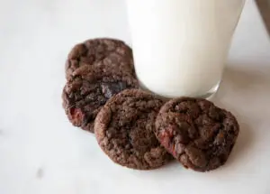 Chocolate cherry cookies with milk on a marble background