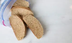 Bread slices with plastic bag on marble and wood
