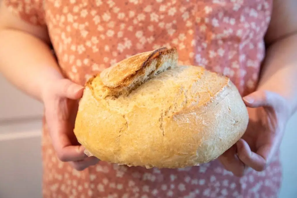 Freshly Milled flour loaf held by woman in pink shirt